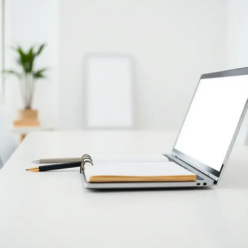 A minimalist modern desk with a notebook, pen, and laptop in a clean office setting, suggesting content creation.