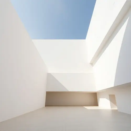 A minimalist modern architectural structure with clean lines and geometric forms in natural daylight.