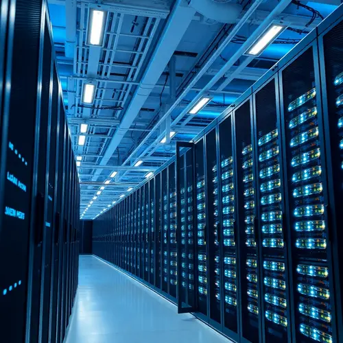Rows of server racks with blinking indicator lights in a large, modern data center.